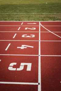 Photo of the finish line of the maroon track. Reading from top to bottom: lanes one through fives. 